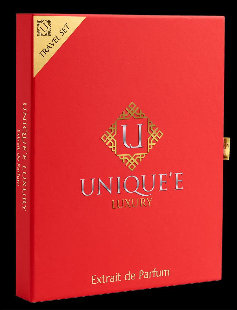 A luxury perfume travel set in a red box with gold detailing, shown open to reveal multiple small perfume vials and two larger bottles. The box features the brand name 'UNIQUE' LUXURY' and the text 'Extrait de Parfum'.